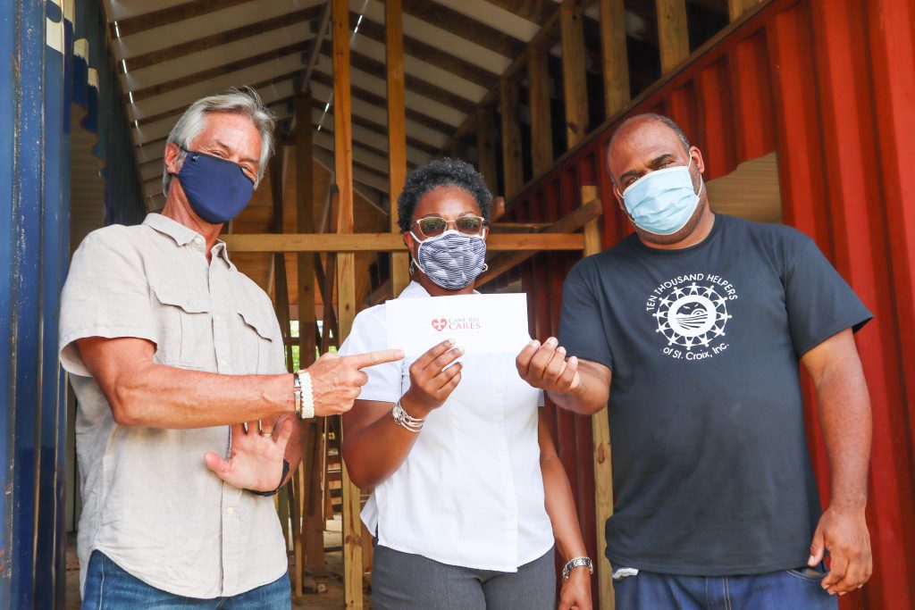 Cane Bay Partners' Jay Clark (left) and Cane Bay Cares' Neisha Christopher-Christian (center) pose with Malik Stridiron, Ten Thousand Helpers of St. Croix executive director, after presenting a donation to support a renovation project to house the homeless and mentally ill.